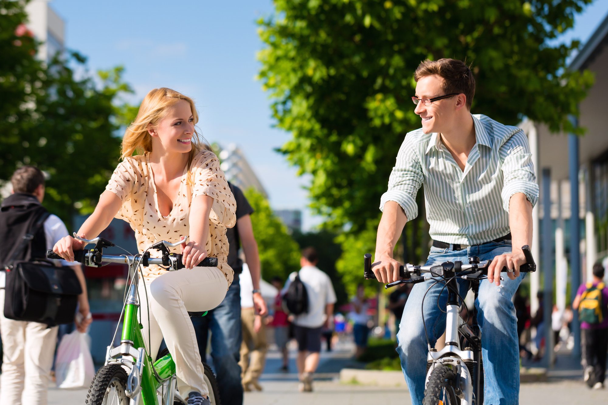 Couple - man and woman - riding their bikes or bicycles in their free time and having fun on a sunny
