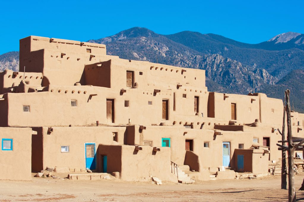 Ancient Taos Pueblo with mountains on background, New Mexico