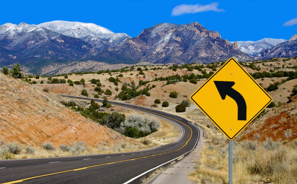 A road sign alerts motorists to a curving mountain road in northern New Mexico.