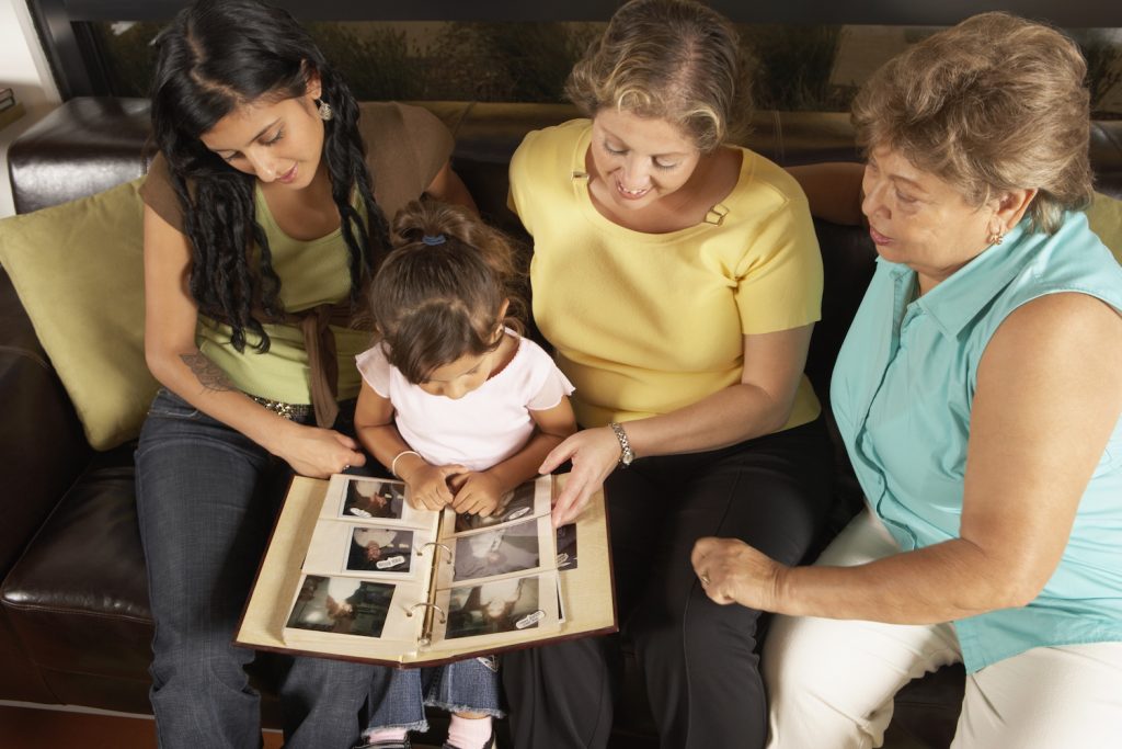 Female members of a family looking at a photo album together