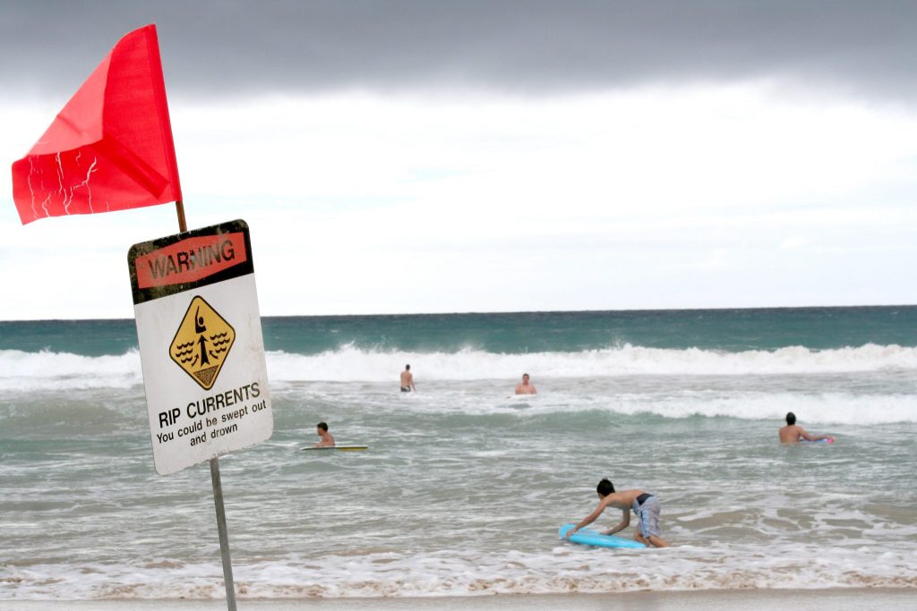 Swimmers are out in the ocean despite the warnings of rip currents.