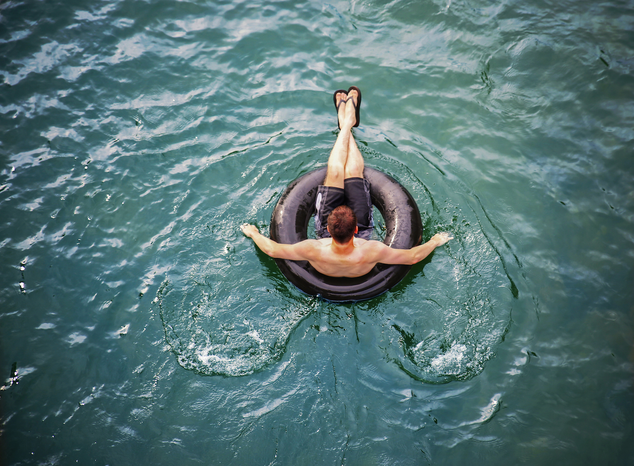 man floating on tube in river