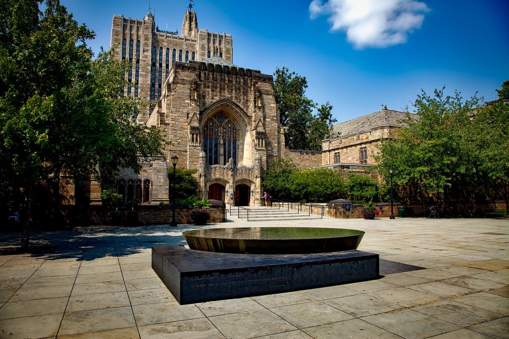 Outside view of the Yale University building, with a small fountain in front 