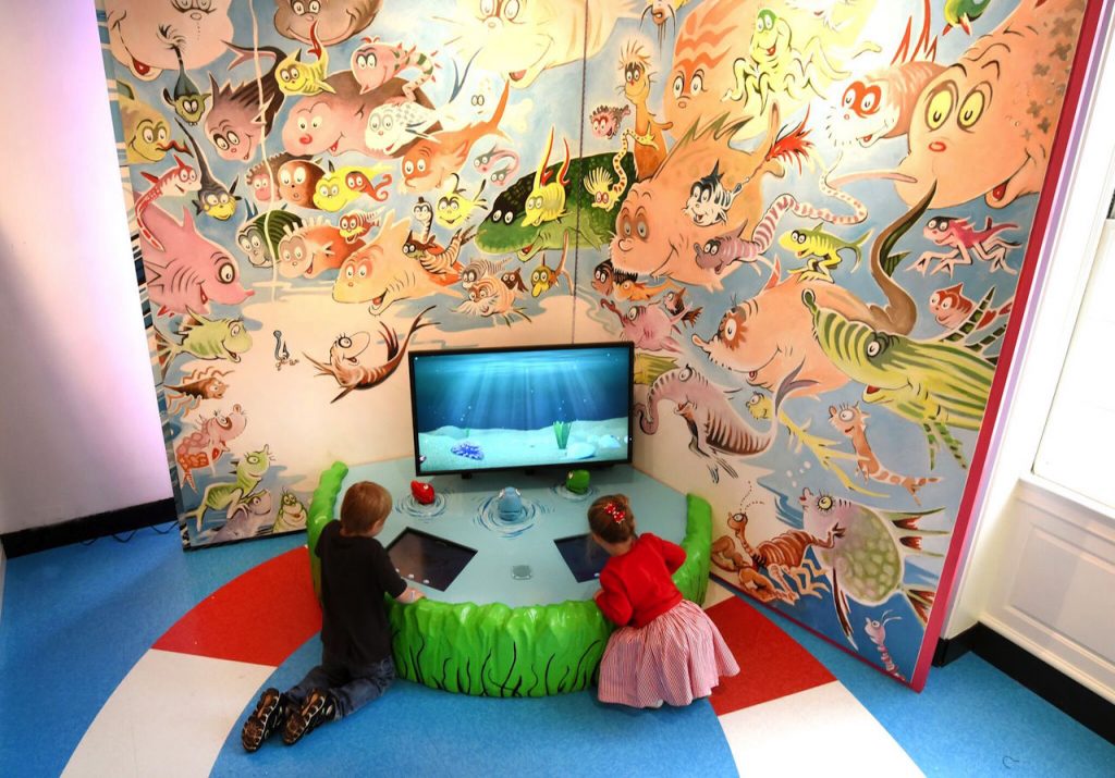 young boy and young girl playing on an interactive dr. seuss game in the Amazing World of Dr. Seuss Museum