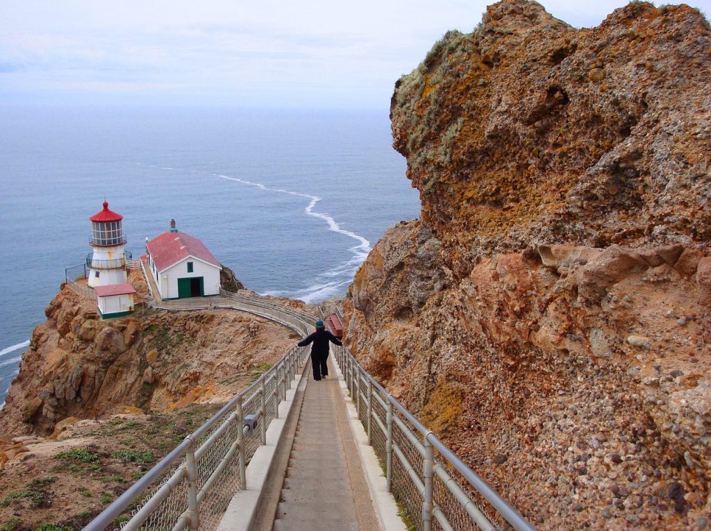 Woman walking down stairs to Point Reyes Lighthouse in California 