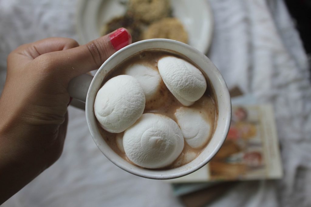 women holding a cup of hot chocolate with giant marshmallows in cup 