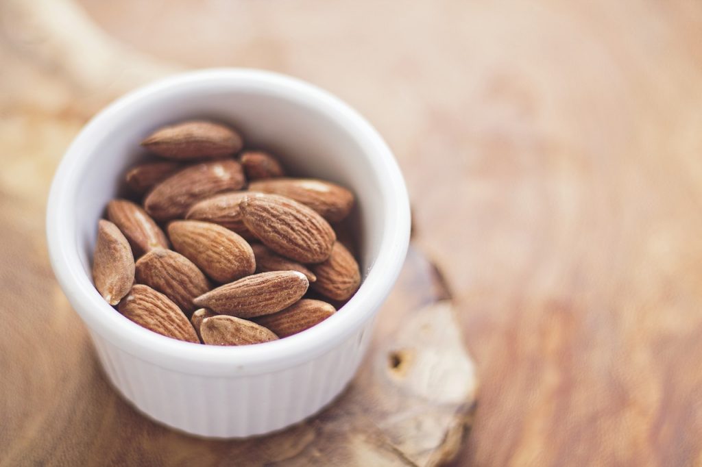 healthy snack; almonds in a white bowl on the table