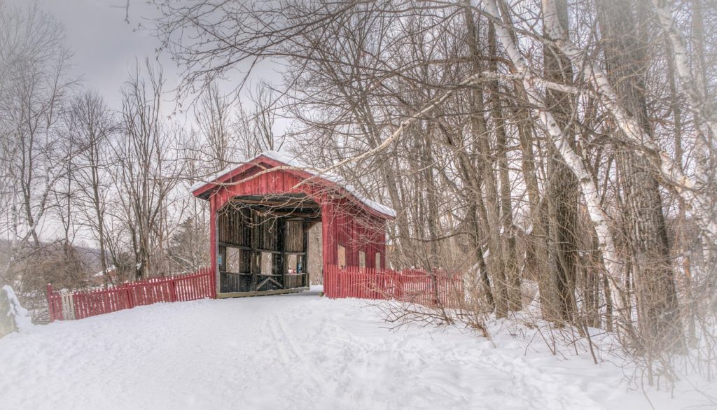 Snow covered red bridge in the middle of Vermont