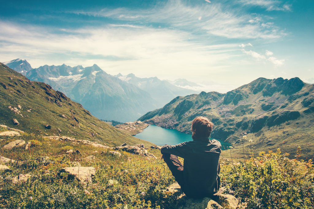 Traveler Man relaxing meditation with serene view mountains and lake landscape Travel Lifestyle hiking concept summer vacations outdoor